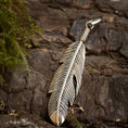 Ladda upp bild i Galleri visare, En Vedhæng Feather 925s Sølv med indviklede detaljer, placeret mod en tekstureret træbark baggrund, ledsaget af en lille plet grønt mos på venstre side.