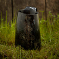 Ladda upp bild i Galleri visare, Vikingekrus Thors Hammer Horn (600-800 ml), et poleret sort hornkrus med et ætset design af Thors Hammer, vises på levende grønt græs mod en rustik træbaggrund.