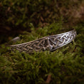 Ladda upp bild i Galleri visare, Et detaljeret Armbånd Armbånd Mjølnir lavet af 925'erne Sterling Sølv, med indviklede keltiske knudemønstre og et lille dragehoved i midten, sat mod en baggrund af frodigt grønt mos.
